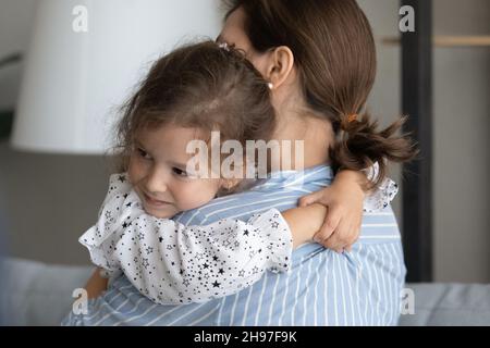 Sweet liebenswert kleines Mädchen umarmt Mutter mit Liebe Stockfoto