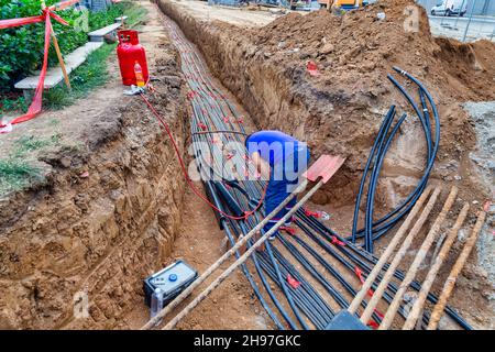 Installation von unterirdischen Stromkabeln während der Umbauarbeiten an der Stadtstraße. Stockfoto