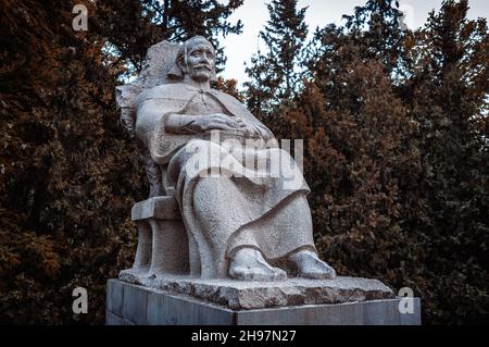 Alte Steinskulptur eines Mannes, der auf dem Thron in der Stadt Tiflis, Georgien sitzt. Stockfoto