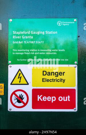 Ein Schild auf dem Gerätekasten an der Stapleford-Messstation am Fluss Granta. Seine warnt Gefahr Strom und Eintritt verboten. Stockfoto