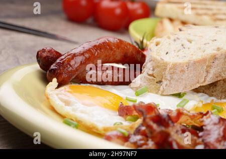 Spiegeleier mit Speck, Würstchen und Gemüse Stockfoto