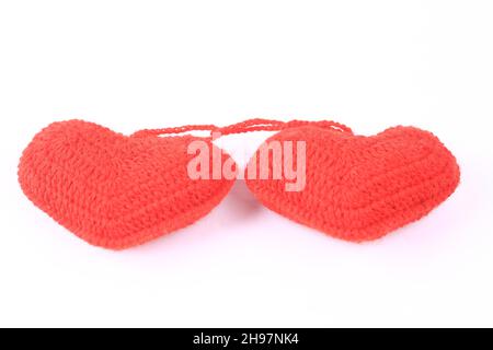 Zwei gestrickte Herzen auf weißem Hintergrund. Kreatives Valentinstags-Konzept Stockfoto