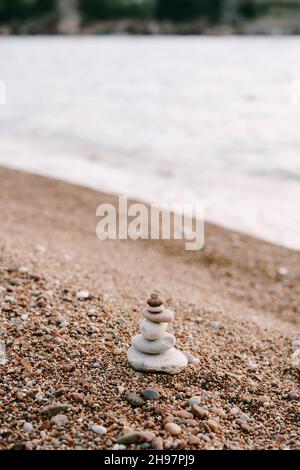 Steinpyramide an einem Kiesstrand am Wasser Stockfoto