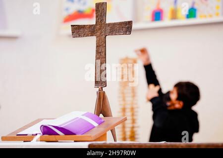 Mannheim, Deutschland. 02nd Dez 2021. Ein Kind baut hinter dem Altar in der Jugendkirche im Stadtteil Waldhof während der Mannheimer Kindervesper 14th einen Turm aus Holzstäben. Bis zum 10. Dezember haben sich insgesamt 25 Schulklassen angemeldet, um dort ein warmes Mittagessen zu erhalten und gemeinsam zu spielen oder zu basteln. (Um dpa ''Kinderarmut zu beenden' - Vesperkirche weist auf Beschwerden hin') Quelle: Uwe Anspach/dpa/Alamy Live News Stockfoto