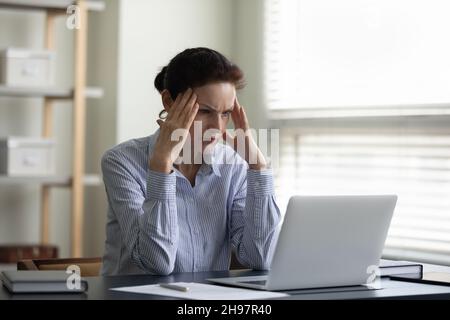 Konzentrierte, konzentrierte Geschäftsfrau mittleren Alters, die hart über Probleme nachdenkt, Stockfoto