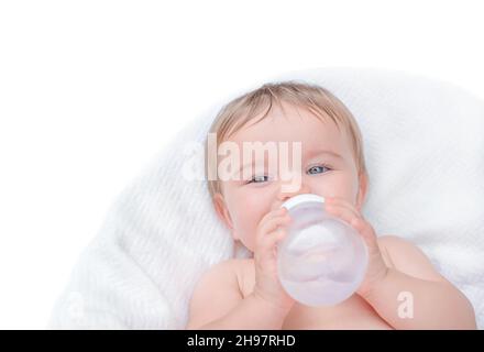 Das Baby trinkt aus einer Flasche. Kind hält Wasserflasche isolieren Stockfoto