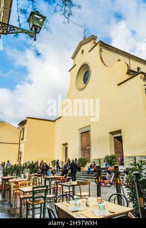 Außenansicht der Kirche Santo Spirito, mit Tischen und Stühlen eines Restaurants, an einem bewölkten Tag, im Oltrarno-Viertel, Florenz, Toskana, Italien Stockfoto