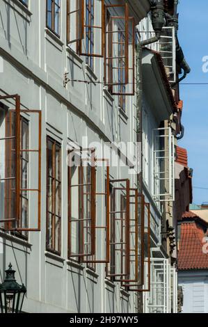 Ein heißer, sonniger Nachmittag in der Prager Altstadt. Die Fenster öffnen sich auf einem Apartmentblock, um jede verfügbare Brise zu fangen. Stockfoto