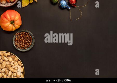 Stillleben von geschälten Mandeln, Walnüssen, Schokolade und rosa Tomaten auf schwarzem Hintergrund Stockfoto