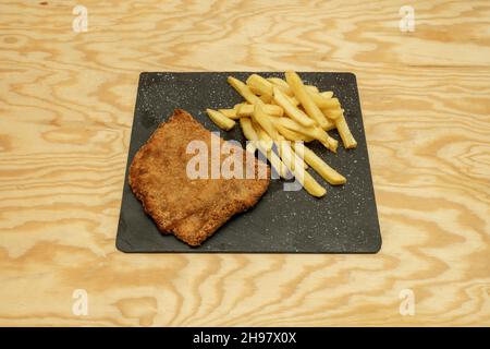 Köstlicher Cachopo mit pommes auf schwarzem Teller Stockfoto