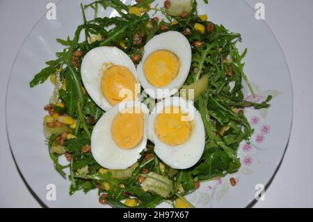 Gekochte Eier in Scheiben geschnitten auf Rucola und Pfeffersalat. Vegetarische Mahlzeit. Stockfoto