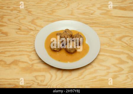 Fleischbällchen in Sauce auf Holztisch Stockfoto