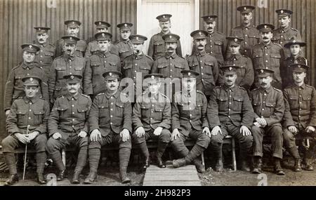 Eine Gruppe britischer Soldaten aus der Zeit des Ersten Weltkriegs in den Royal Fusiliers vor einer Barackenhütte. Ein Pfadfinder ist in der Gruppe ganz rechts. Stockfoto