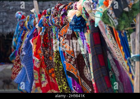 Bunte traditionelle Stoffbekleidung zum Verkauf am Strand, Diani, Kenia Stockfoto