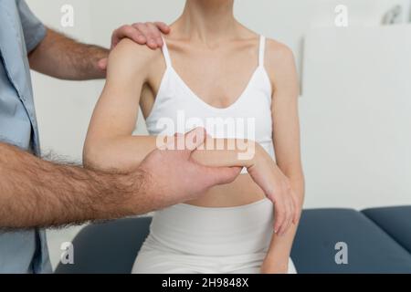 Osteopathische Arm- oder Schultermassage. Schmerzlinderung der Ellenbogen. Chiropraktische Behandlung. Arzt, der eine Schulterblatt-Therapie macht. Stretching und Bewegung, tun Stockfoto