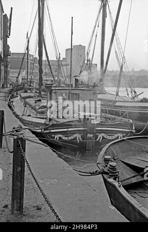 Das Wet Dock im Hafen von Ipswich, Suffolk, England, UK, fotografiert in den letzten Tagen des Handelsverkehrs Mitte 1960s. Hier werden noch immer Thames-Segelschiffe, hauptsächlich für den Getreidehandel, auf dem Fluss Orwell und der Nordsee eingesetzt. Das Zentrum ist ‘Beric’, ein 63 Tonnen schweres Holzkahn, das 1896 in Harwich, Essex gebaut wurde. Das Hafengebiet hier ist nun fast ausschließlich Wohngebieten, Bildungsentwicklungen und Freizeitaktivitäten gewidmet. Der Dock selbst ist der Heimhafen für Freizeitboote aller Formen und Größen – ein Vintage-Foto aus dem Jahr 1960s. Stockfoto