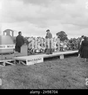 Carlisle, Cumbria, 19/06/1954. Kinder, die während eines Sporttages im Carlisle Sports Club von Laing in einem Miniaturzug namens „Brisco Belle“ fahren. Am 19th. Juni 1954 fand im Sports Club in Carlisle ein jährlicher Sporttag statt. Die Aktivitäten begannen zwischen 2pm und 11pm, darunter ein Programm mit Leichtathletik-Veranstaltungen, Side-Shows, ein Buffet-Tee, eine Filmshow und Tanz im Festzelt. Stockfoto