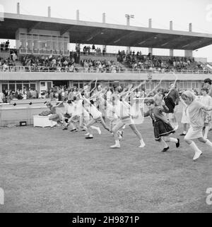 Copthall Stadium, Hendon, Barnett, London, 25/06/1966. Beim jährlichen Laing Sports Day im Copthall-Stadion verlassen die Mädchen die Startlinie eines Springsrennens mit Zuschauern in einem Stand darüber hinaus. Im Jahr 1966 fand am 25th. Juni der jährliche Laing Employees' Sports Day im Copthall Stadium in Hendon statt. Es war das erste Mal, dass die Veranstaltung dort stattfand, nachdem zuvor der Laing Sports Ground in Elstree stattgefunden hatte. Eine Reihe von Veranstaltungen umfasste Leichtathletik und einen Fußballwettbewerb, und die Teilnehmer reisten von den regionalen Büros und Standorten des Unternehmens, darunter aus Schottland und Carlisle. Es gab Stockfoto