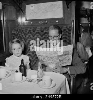 Ausflug von Laings Londoner Büro nach Bournemouth, 30/05/1953. Ein Mann und ein junges Mädchen saßen in einer Zugkutsche mit Erfrischungen während eines Ausflugs von Laings Londoner Büro nach Bournemouth, wobei der Mann eine spezielle Krönungsausgabe von Team Spirit vorlas. Stockfoto