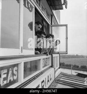 Imperial Cafe, Skegness, Skegness, East Lindsey, Lincolnshire, 22/05/1954. Eine Gruppe von Männern und eine Frau, die sich während eines Laing-Aufenthalts nach Skegness aus einem Fenster im ersten Stock im Imperial Cafe lehnten. Im Jahr 1947, nach einer siebenjährigen Pause, hatte Laing seine „Ausflüge in die Umgebung“ für Mitarbeiter und ihre Familien wiederbelebt, wobei die Reisen im Mai und Juni stattfinden. Im Jahr 1954 waren sieben Ausflüge geplant, die über fünf Wochen im Mai und Juni stattfinden sollen. Diese Reise nach Skegness war für Mitarbeiter und ihre Familien aus den Midlands und South Yorkshire. Eine ausgeschnittene Version dieses Fotos wurde im Juli 195 veröffentlicht Stockfoto