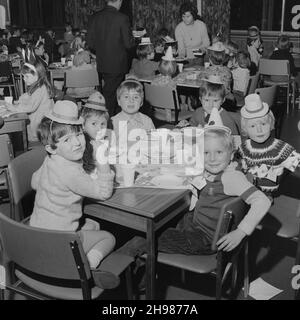 John Laing and Son Limited, Page Street, Mill Hill, Barnett, London, 18/12/1971. Kinder tragen Partyhüte, haben Tee auf einer Weihnachtsfeier. Diese Party in der Laing-Mitarbeiterkantine in ihrem Büro in Mill Hill wurde für mehr als 150 Kinder verlegt, die von der Catering-Abteilung versorgt wurden. Stockfoto