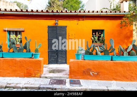 Außenansicht eines lebhaften orangefarbenen Hauses mit Topfkakteen in der Carrer del Polvorí, El Terreno, Palma, Mallorca, Spanien Stockfoto