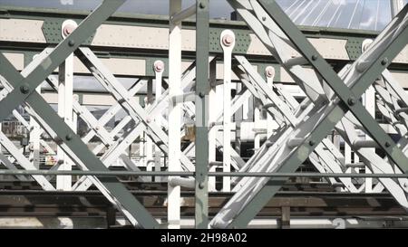 Nahaufnahme des weißen Wagens, der schnell auf der Brücke gegen den blauen Himmel fährt. Städtischer Schienenverkehr Stockfoto