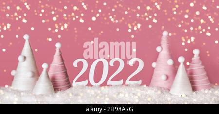 DIY Weihnachtsbäume aus rosa Garn und 2022 auf rosa Hintergrund. Öko-flauschiges Weihnachtsdekor, Bannerformat Stockfoto