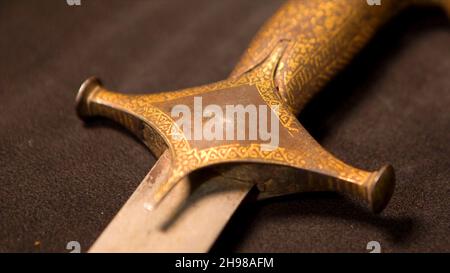 Nahaufnahme der Muster des Griffs der mittelalterlichen Waffe. Archivmaterial. Alte Waffen der slawischen oder östlichen Menschen im Museum auf isoliertem Hintergrund. Stockfoto