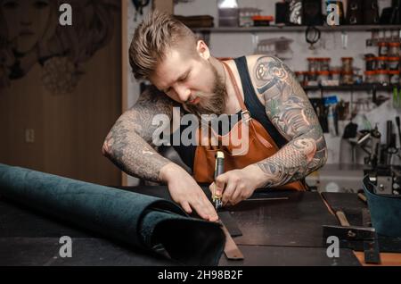 Leather Currier schafft neue Lederarbeiten in seinem Gerbershop Stockfoto