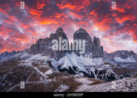 Dramatische Abendlandschaft mit drei Gipfeln der Lavaredo-Berge, glühender Straße und rosa Sonnenuntergangshimmel. auronzo refugio im Nationalpark Tre Cime Di Lavaredo, Dolomiten, Trentino-Südtirol, Italien Stockfoto