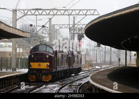 Zwei Diesel-elektrische Lokomotiven der Baureihe 37 in West Coast-Eisenbahnen durchfahren den Bahnhof Carnforth auf einer Probefahrt, 29th. November 2021. Stockfoto