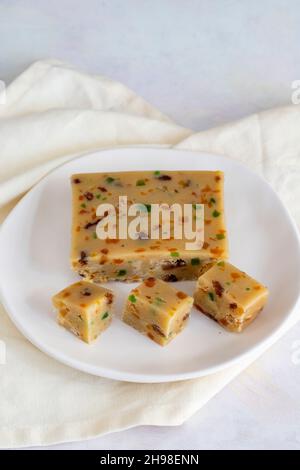 Obst-Halva. Halva auf Holzhintergrund. Türkische Halvah für türkisches Frühstück. Lokaler Name meyveli yaz helvası Stockfoto