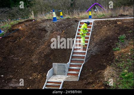 Taplow, Buckinghamshire, Großbritannien. 5th. Dezember 2021. Neben der M4 werden Fußgänger-Fluchttreppen installiert. Die M4 ist an diesem Wochenende wieder in beide Richtungen zwischen der Anschlussstelle 6 für Slough und der Anschlussstelle 8/9 in Maidenhead geschlossen. Der M4 wird zu einer All Lanes Running Digital Smart Motorway ausgebaut, die keine harte Schulter mehr hat, sondern zeitweise Schutzgebiete für Pannenausfälle hat. In den vergangenen fünf Jahren sind in Großbritannien 38 Menschen auf intelligenten Autobahnen ums Leben gekommen. Eine Aktualisierung der Smart Motorway auf dem M3 wurde nach einer Sicherheitsuntersuchung ausgesetzt. Quelle: Maureen McLean/Alamy Live News Stockfoto