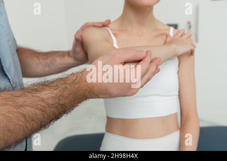 Osteopathische Arm- oder Schultermassage. Schmerzlinderung der Ellenbogen. Chiropraktische Behandlung. Arzt, der eine Schulterblatt-Therapie macht. Stretching und Bewegung, tun Stockfoto