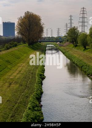 Oberhausen, Nordrhein-Westfalen, Deutschland - 28. April 2021: Blick auf die Emscher mit dem Gasometer im Hintergrund Stockfoto