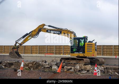 Dorney Reach, Buckinghamshire, Großbritannien. 5th. Dezember 2021. Bauarbeiter zerstörten heute eine Mauer neben dem Fußgängerweg neben dem M4, was den Dorfbewohnern in Dorney Reach Lärm und Staub verursachte. Die M4 ist an diesem Wochenende wieder in beide Richtungen zwischen der Anschlussstelle 6 für Slough und der Anschlussstelle 8/9 in Maidenhead geschlossen. Der M4 wird zu einer All Lanes Running Digital Smart Motorway ausgebaut, die keine harte Schulter mehr hat, sondern zeitweise Schutzgebiete für Pannenausfälle hat. In den vergangenen fünf Jahren sind in Großbritannien 38 Menschen auf intelligenten Autobahnen ums Leben gekommen. Ein Smart Motorway-Upgrade auf dem M3 wurde durchgeführt Stockfoto