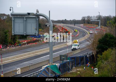 Dorney Reach, Buckinghamshire, Großbritannien. 5th. Dezember 2021. Bauarbeiter wurden eine Mauer neben dem Fußgängerweg neben dem M4 abgerissen, was heute Lärm und Staub für die Dorfbewohner in Dorney Reach verursacht. Die M4 ist an diesem Wochenende wieder in beide Richtungen zwischen der Anschlussstelle 6 für Slough und der Anschlussstelle 8/9 in Maidenhead geschlossen. Der M4 wird zu einer All Lanes Running Digital Smart Motorway ausgebaut, die keine harte Schulter mehr hat, sondern zeitweise Schutzgebiete für Pannenausfälle hat. In den vergangenen fünf Jahren sind in Großbritannien 38 Menschen auf intelligenten Autobahnen ums Leben gekommen. Ein Smart Motorway Upgrade auf dem M3 hat BEE Stockfoto