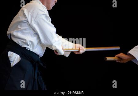 Florenz, Italien - 2021. November 27: Aikido-Meister mit schwarzem Gürtel während einer Trainingseinheit beim Japanese Festival 2021. Schwarzer Hintergrund. Stockfoto