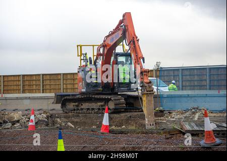 Dorney Reach, Buckinghamshire, Großbritannien. 5th. Dezember 2021. Bauarbeiter zerstörten heute eine Mauer neben dem Fußgängerweg neben dem M4, was den Dorfbewohnern in Dorney Reach Lärm und Staub verursachte. Die M4 ist an diesem Wochenende wieder in beide Richtungen zwischen der Anschlussstelle 6 für Slough und der Anschlussstelle 8/9 in Maidenhead geschlossen. Der M4 wird zu einer All Lanes Running Digital Smart Motorway ausgebaut, die keine harte Schulter mehr hat, sondern zeitweise Schutzgebiete für Pannenausfälle hat. In den vergangenen fünf Jahren sind in Großbritannien 38 Menschen auf intelligenten Autobahnen ums Leben gekommen. Ein Smart Motorway-Upgrade auf dem M3 wurde durchgeführt Stockfoto