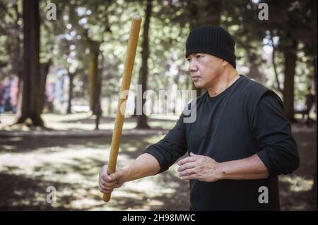 Der LAMECO Astig Combatives-Instruktor demonstriert Techniken und Trainingsmethoden für Einzelstäbchen. Philippinische Kampfkunst. Ecrima, Kali, Arnis Stockfoto