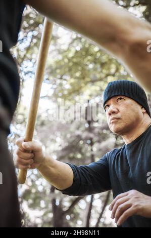 Der LAMECO Astig Combatives-Instruktor demonstriert Techniken und Trainingsmethoden für Einzelstäbchen. Philippinische Kampfkunst. Ecrima, Kali, Arnis Stockfoto