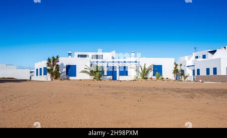 Typische kanarische weiße und blaue Häuser in der Stadt Caleta del Sebo auf der Insel La Graciosa, in der Nähe von Lanzarote in Spanien. Wunderschönes traditionelles Haus auf menschenleer Stockfoto