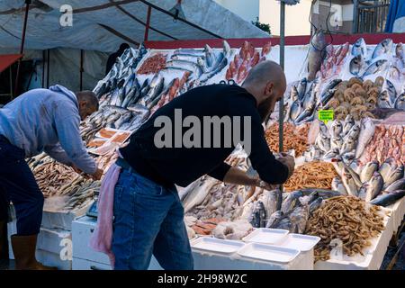 Kemer, Türkei - 08. November 2021: Händler arrangieren Produkte an einer Theke auf einem Fischmarkt Stockfoto