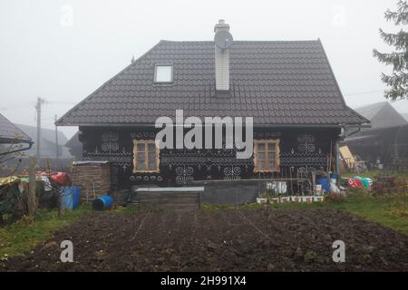 Traditionelles Blockhaus mit weißen linearen Mustern im Dorf Čičmany in der Region Žilina in der Slowakei. Stockfoto