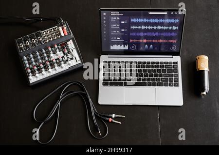 Draufsicht Hintergrundbild von Aufnahmesequipment und Laptop mit Audio-Tracks im Studio, Kopierraum Stockfoto