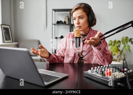 Portrait einer weiblichen Content-Creator sprechen, um Mikrofon während der Aufnahme Podcast im Studio, kopieren Raum Stockfoto
