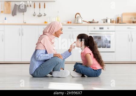 Mutter Und Kind. Happy Muslim Mutter Und Kleine Tochter Bonding In Küche Stockfoto