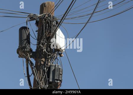 Viele Kabel rufen Stromkabel auf einem Mast zusammen Stockfoto