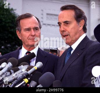 **DATEI FOTO** Bob Dole ist bei 98 verstorben. Der designierte Präsident der Vereinigten Staaten, George H.W. Bush und der Minderheitsführer des US-Senats, Bob Dole (Republikaner von Kansas), treffen sich am 28. November 1988 im Gebäude des alten Exekutivbüros in Washington, DC mit Reportern nach ihrem Mittagessen.Quelle: Ron Sachs /MediaPunch Stockfoto